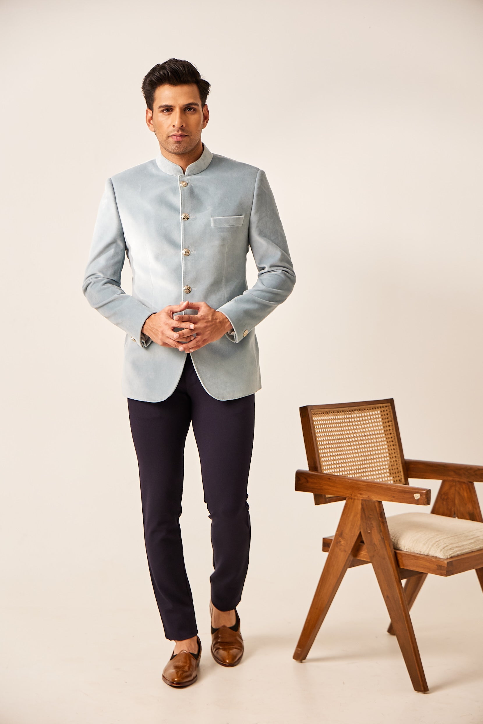 A man poses in a Sky Volite cotton suede Jodhpuri jacket with a refined, plain design, accented by antique buttons for a polished finish.