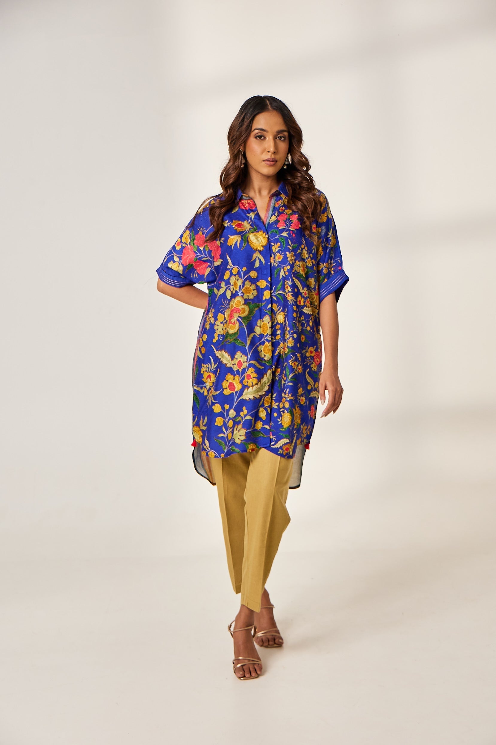 A woman poses in a navy blue silk kurti with a floral print and backstitched collar and sleeves from BenzerWorld.