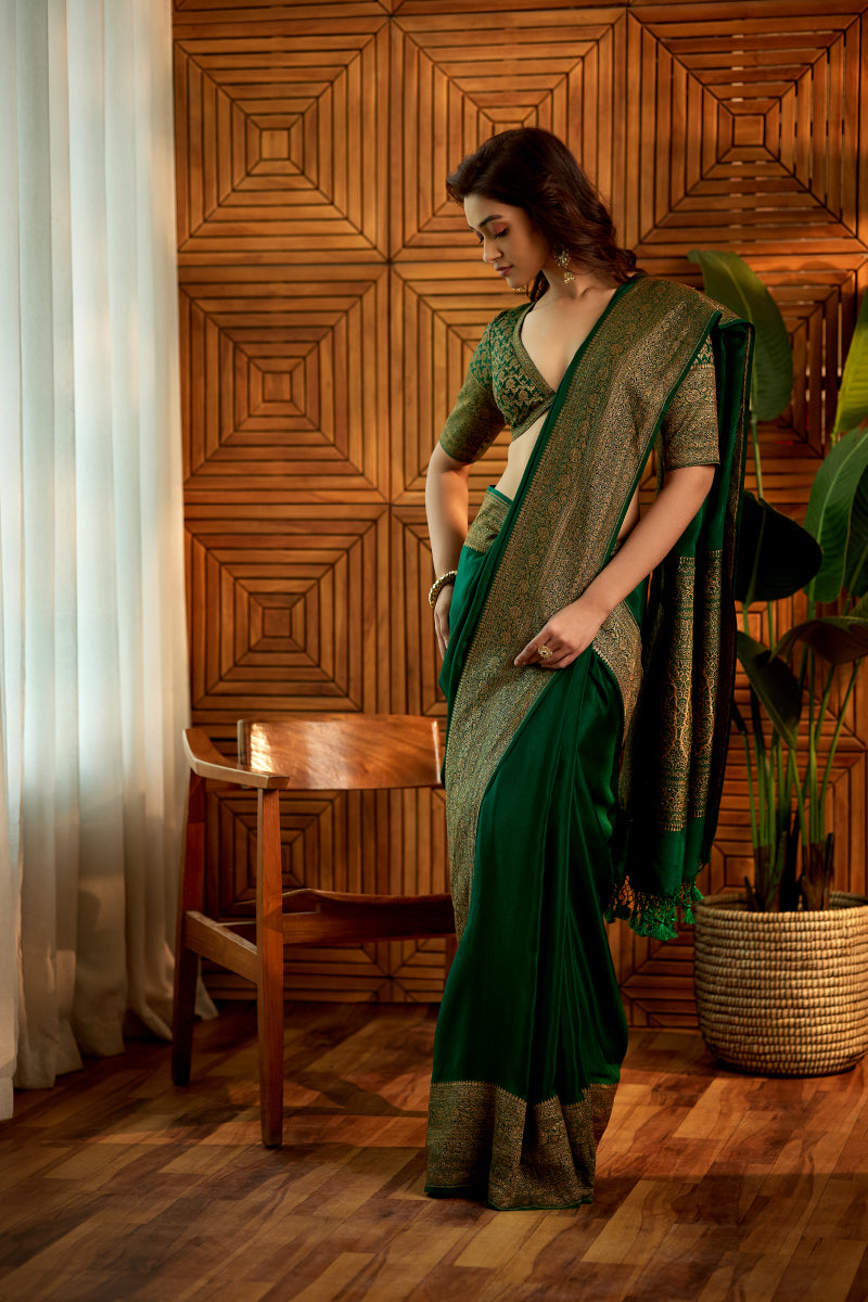 A woman poses in a bottle-green crepe silk saree with an unstitched blouse from BenzerWorld ethnicwear store.