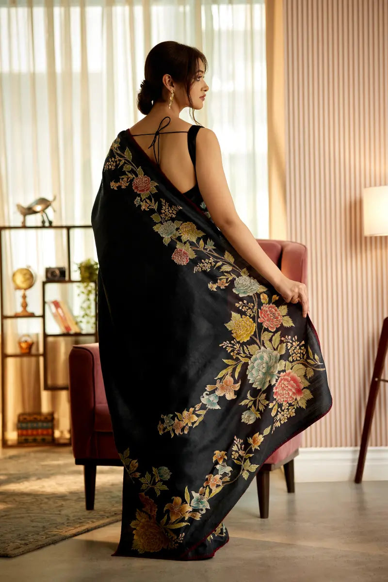A woman poses in a greyish black tussar silk saree with an unstitched blouse from BenzerWorld ethnicwear store.