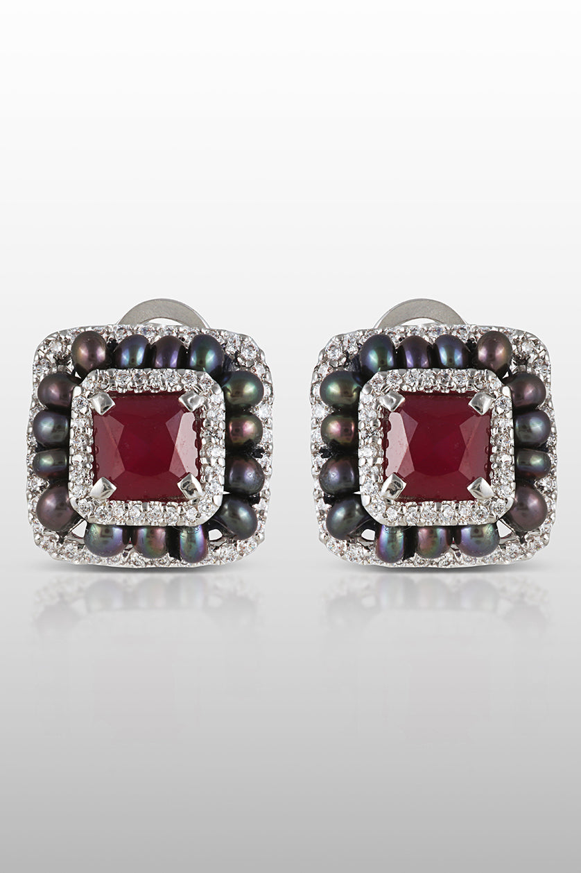A closeup of sterling silver earrings with semi precious ruby stones and cubic zircon from BenzerWorld ethnicwear store.