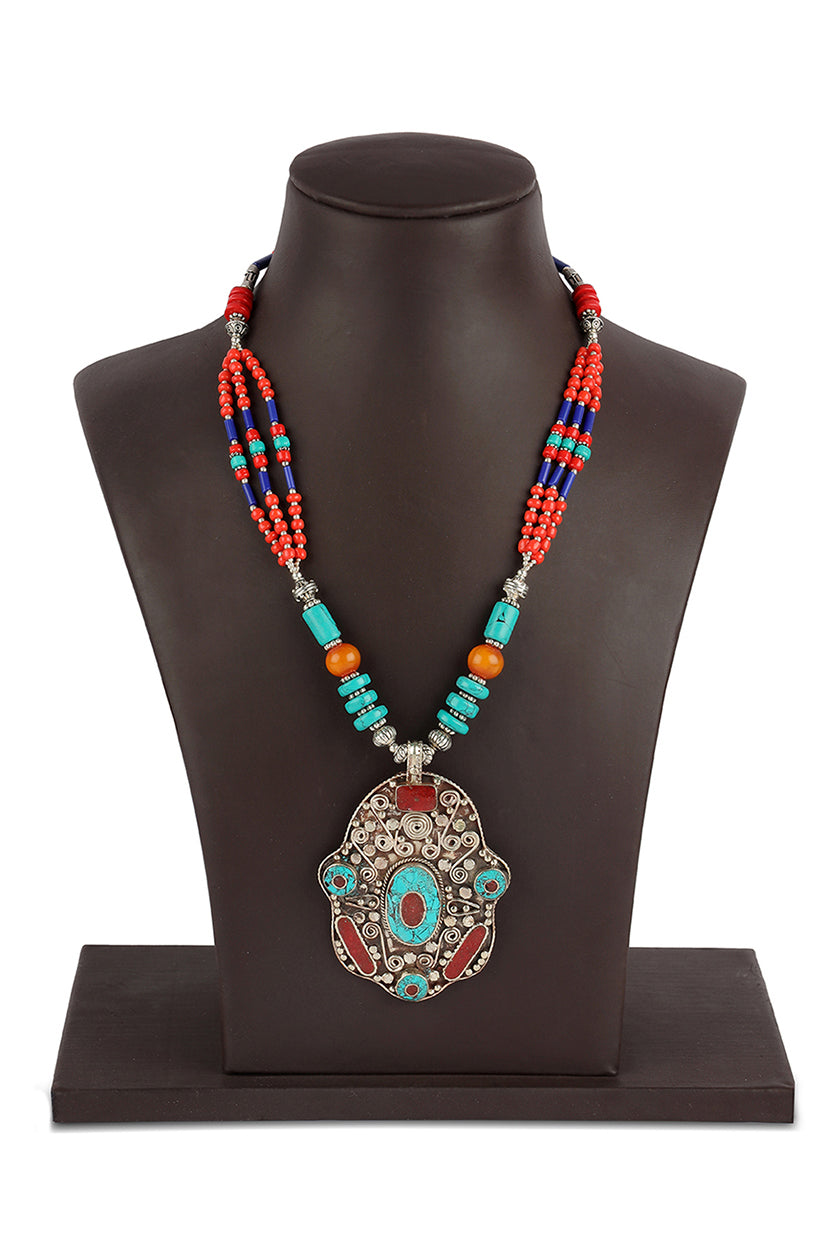 A closeup of an antique pendant with colorful beads from BenzerWorld ethnicwear store.