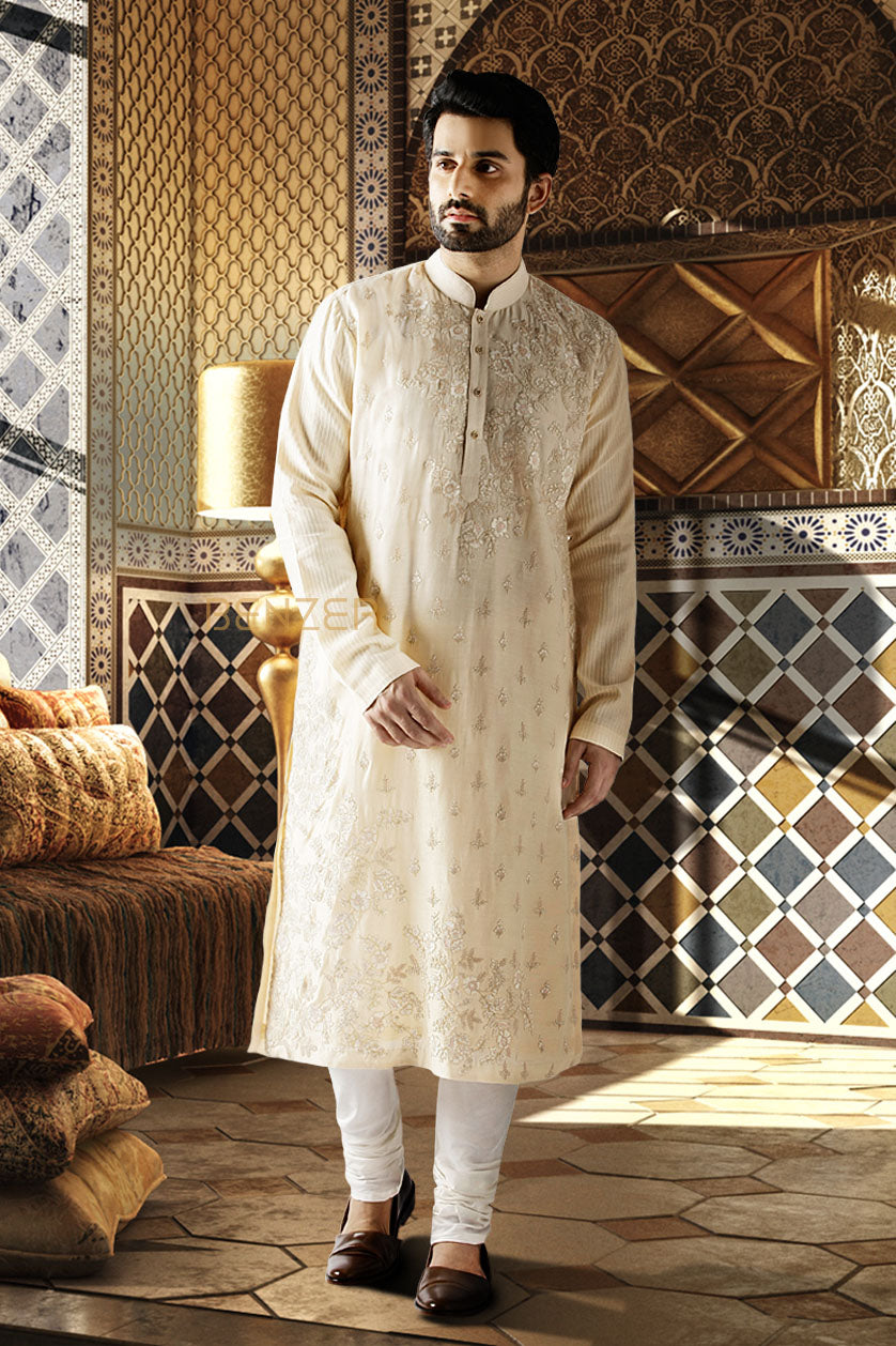 A man poses in a beige cotton silk printed kurta set from BenzerWorld ethnicwear store.