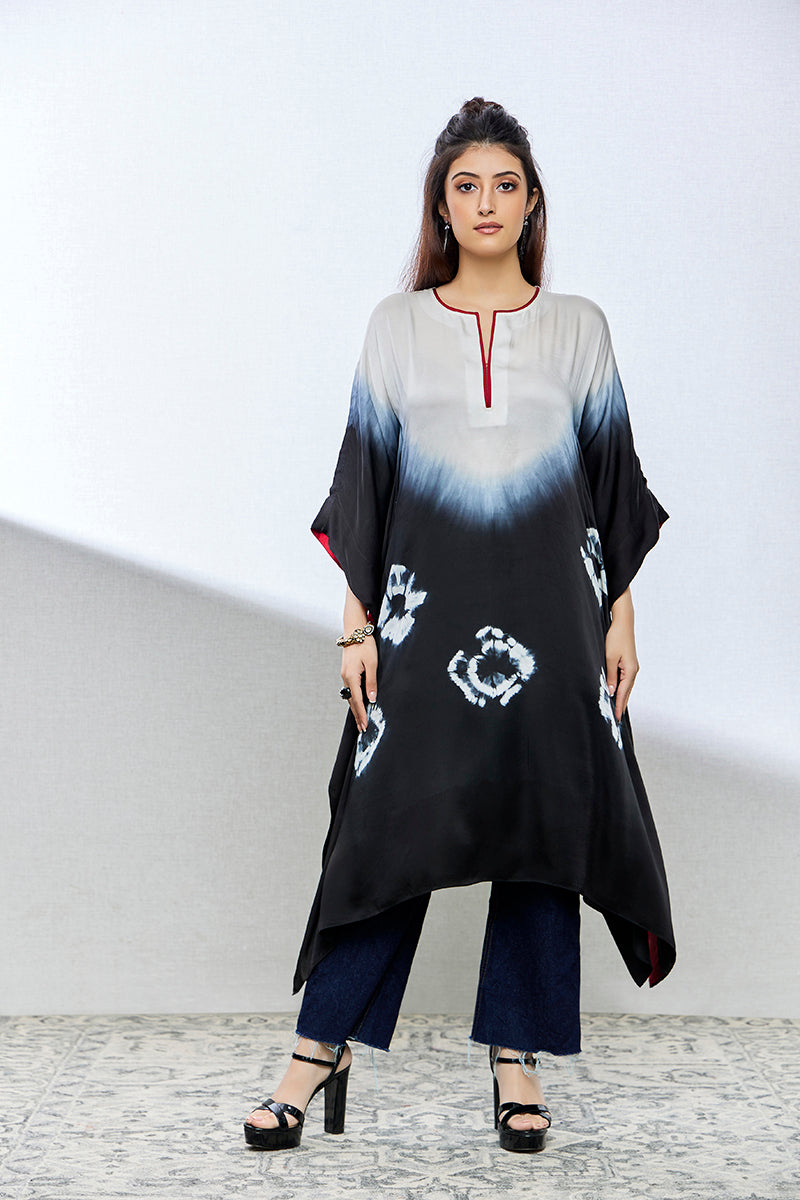 A woman poses in a black and white tie-dyed satin silk kurti from BenzerWorld ethnicwear store, while looking ahead.
