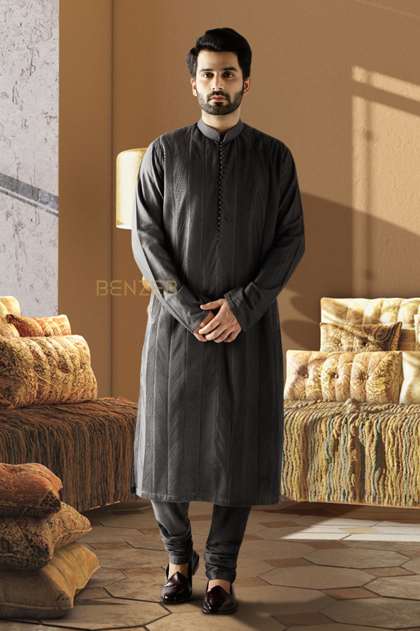 A man poses in a black cotton silk embroidered kurta set from BenzerWorld ethnicwear store.