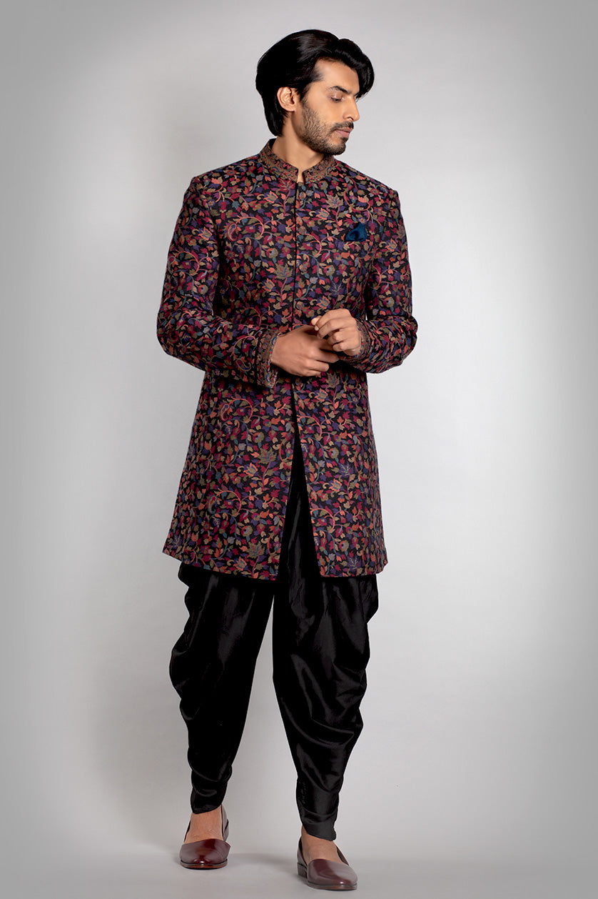 A man poses in a black pashmina sangeet outfit from BenzerWorld ethnicwear store.