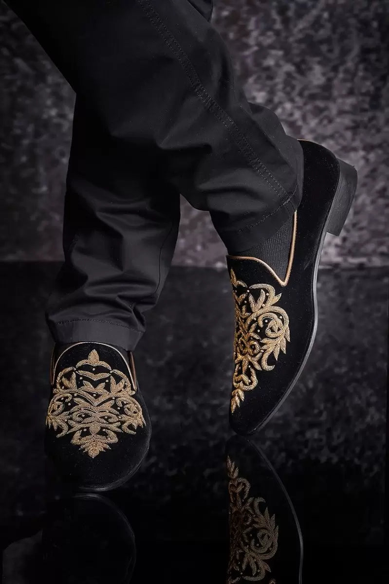 A man in black velvet shoes from BenzerWorld ethnicwear store poses for the camera.