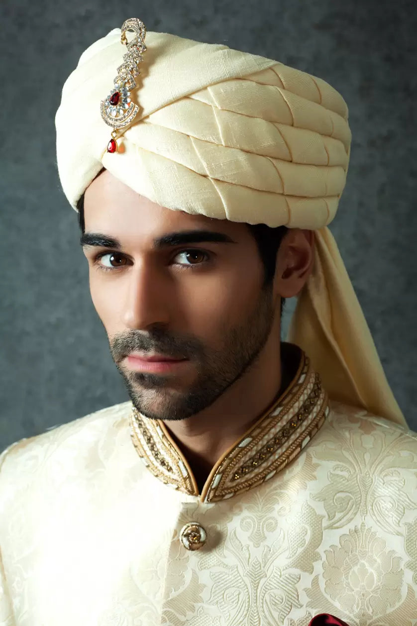 A man poses in a cream cotton silk turban from BenzerWorld ethnicwear store.