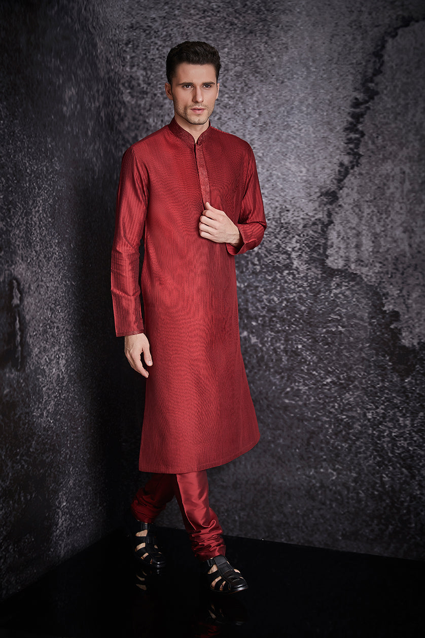 A man poses in a crimson red silk plain kurta set from BenzerWorld ethnicwear store.
