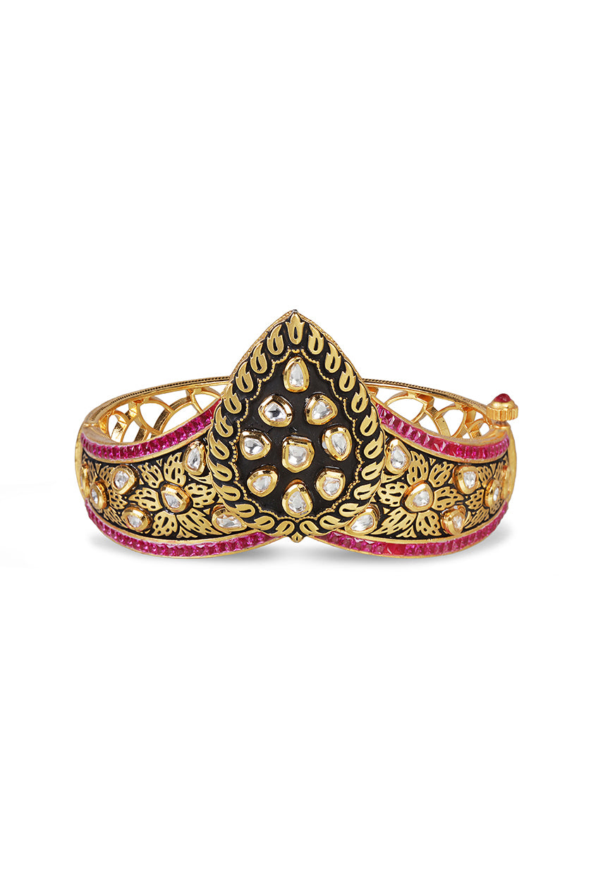 A closeup of a crown-shaped kada in vilandi with black meenakari work from BenzerWorld ethnicwear store.