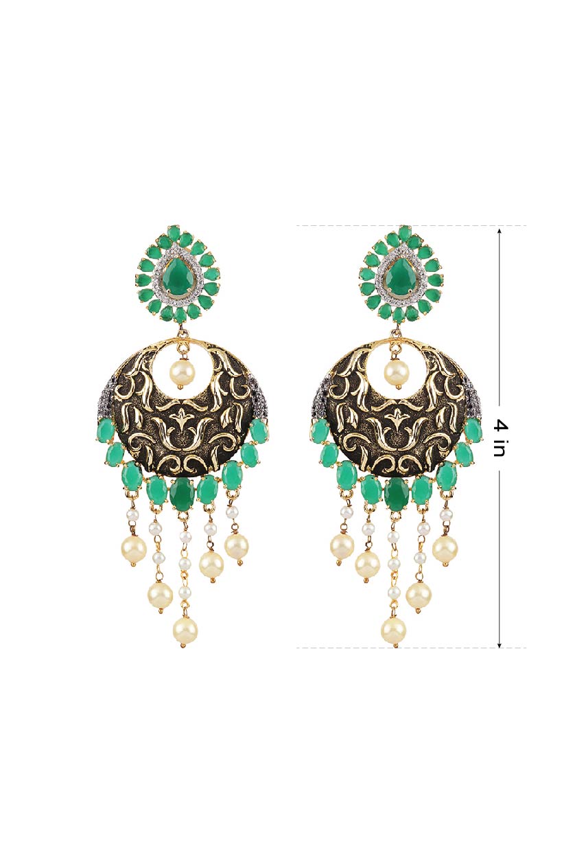 A closeup of gold antique finish earrings with green stoness from BenzerWorld ethnicwear store.