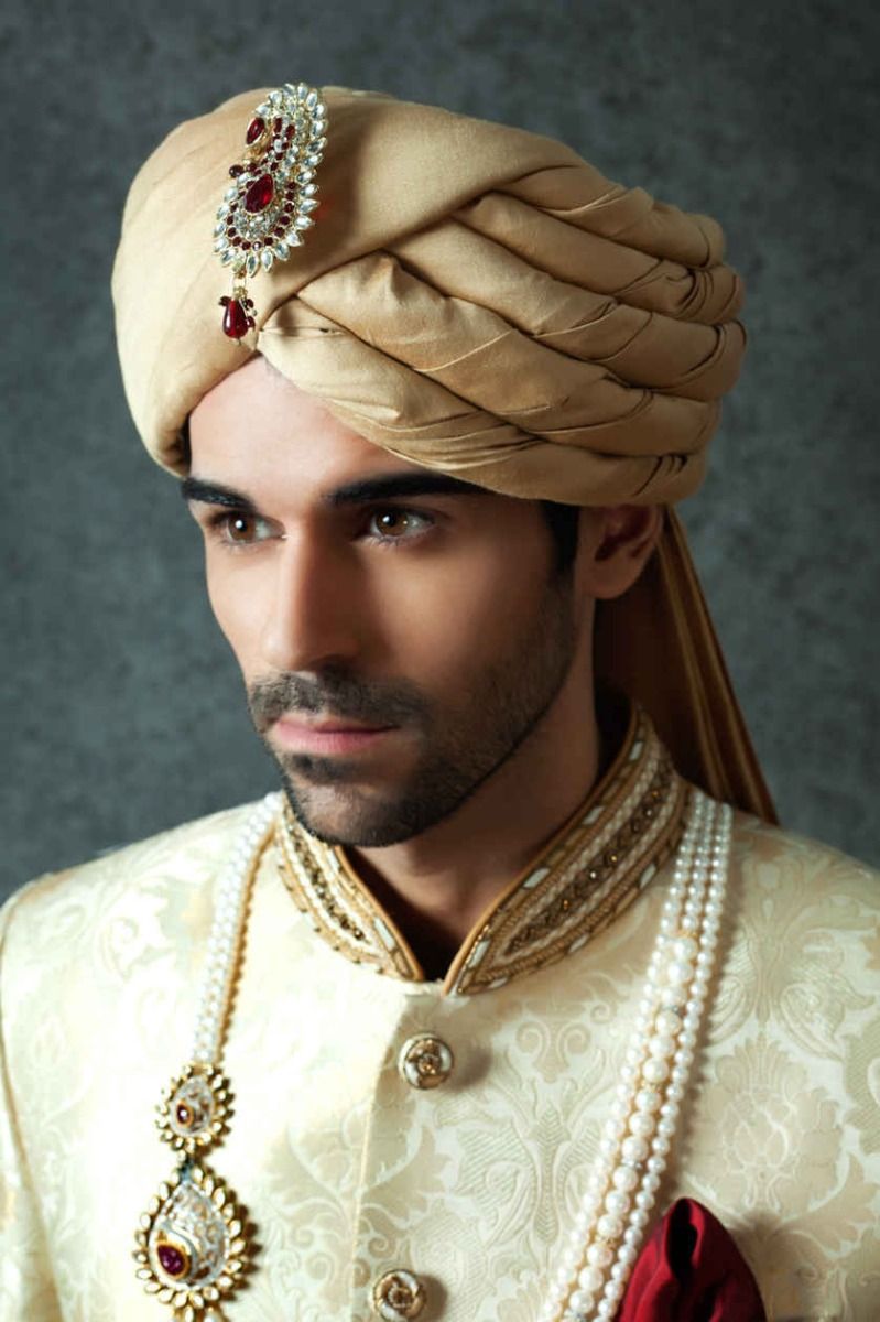 A man poses in a golden cotton silk turban from BenzerWorld ethnicwear store.