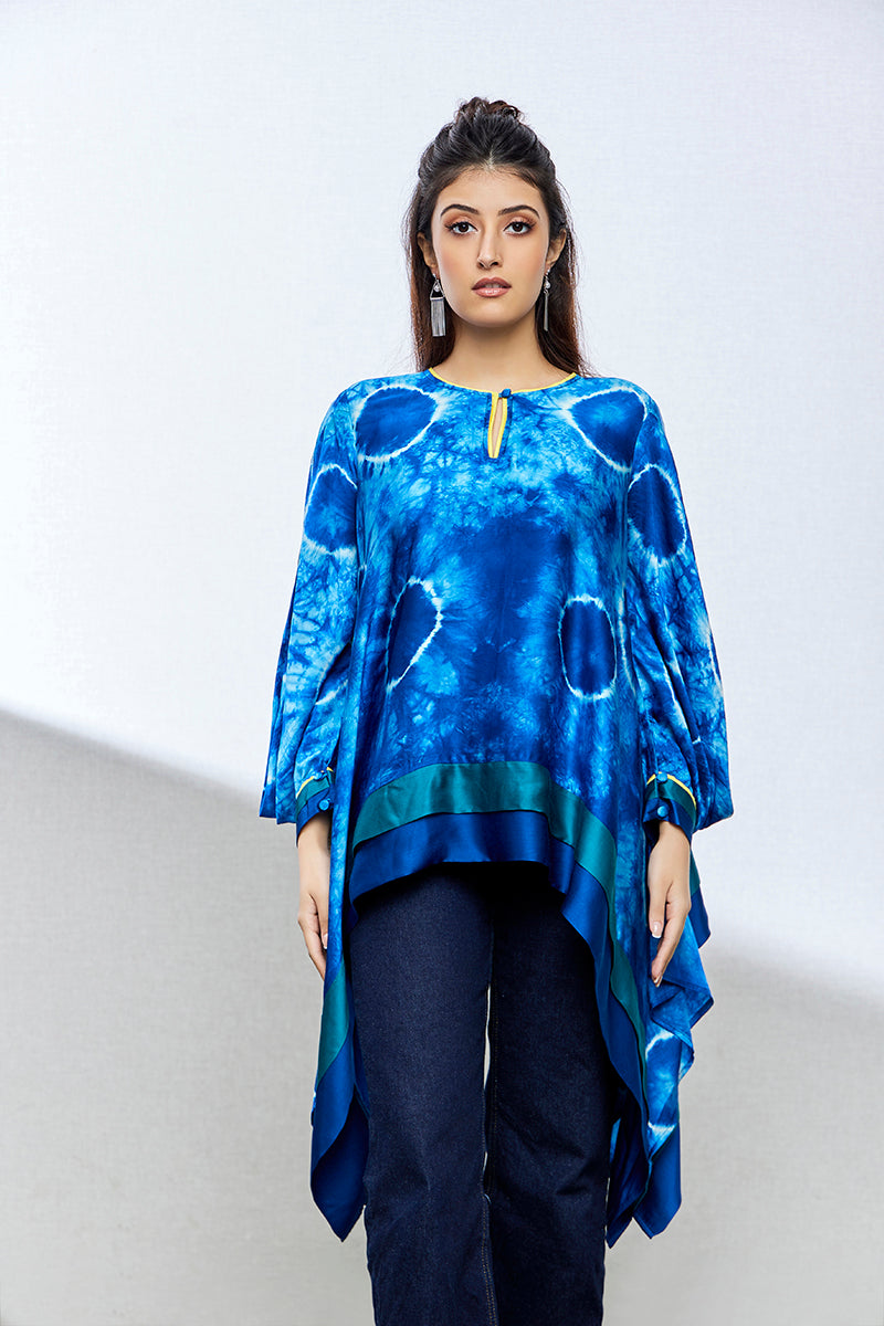 A woman poses in an indigo tie-dyed satin silk kurti from BenzerWorld ethnicwear store, as she looks ahead.