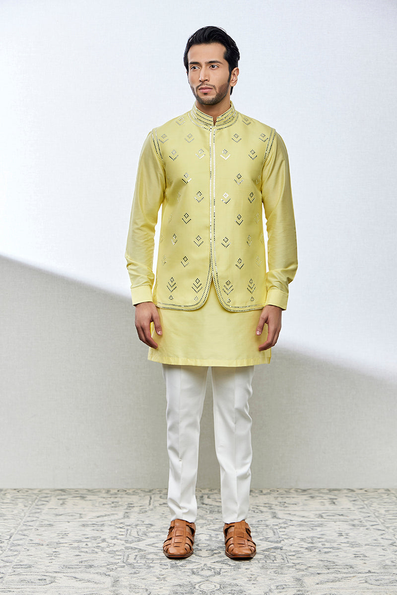 A man poses in a lemon-yellow cotton silk kurta set from BenzerWorld ethnicwear store.