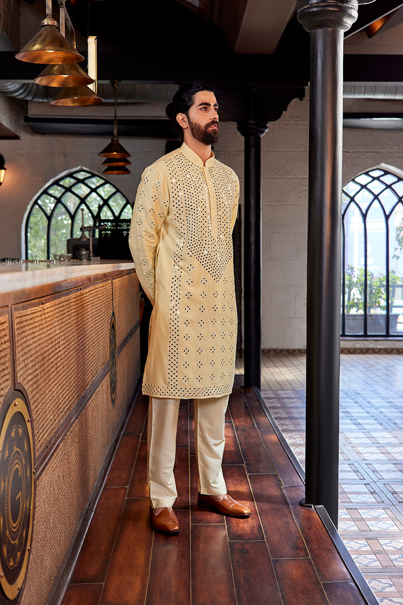 A man in a lemon yellow pure silk kurta set from BenzerWorld ethnicwear store poses in standing position.