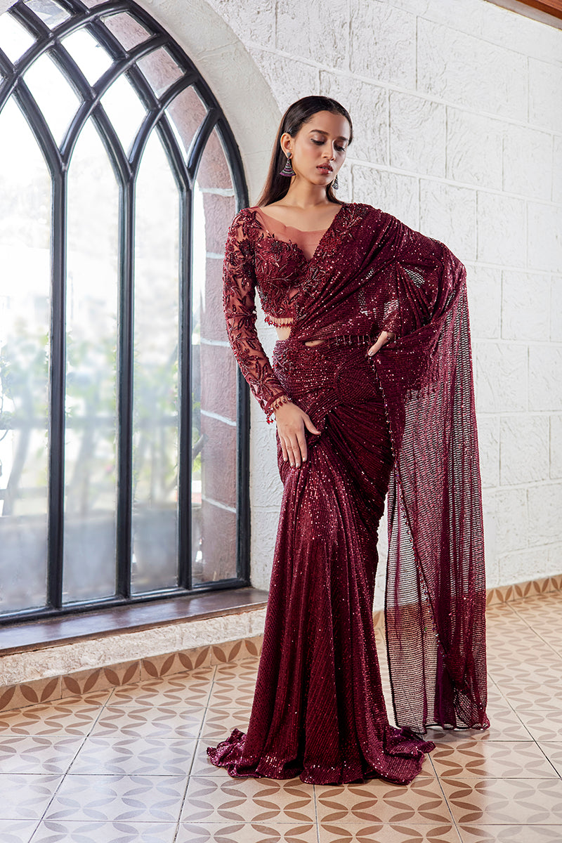 A woman poses in an off-white chanderi silk ladies suit from BenzerWorld ethnicwear store, as she leans against a column.