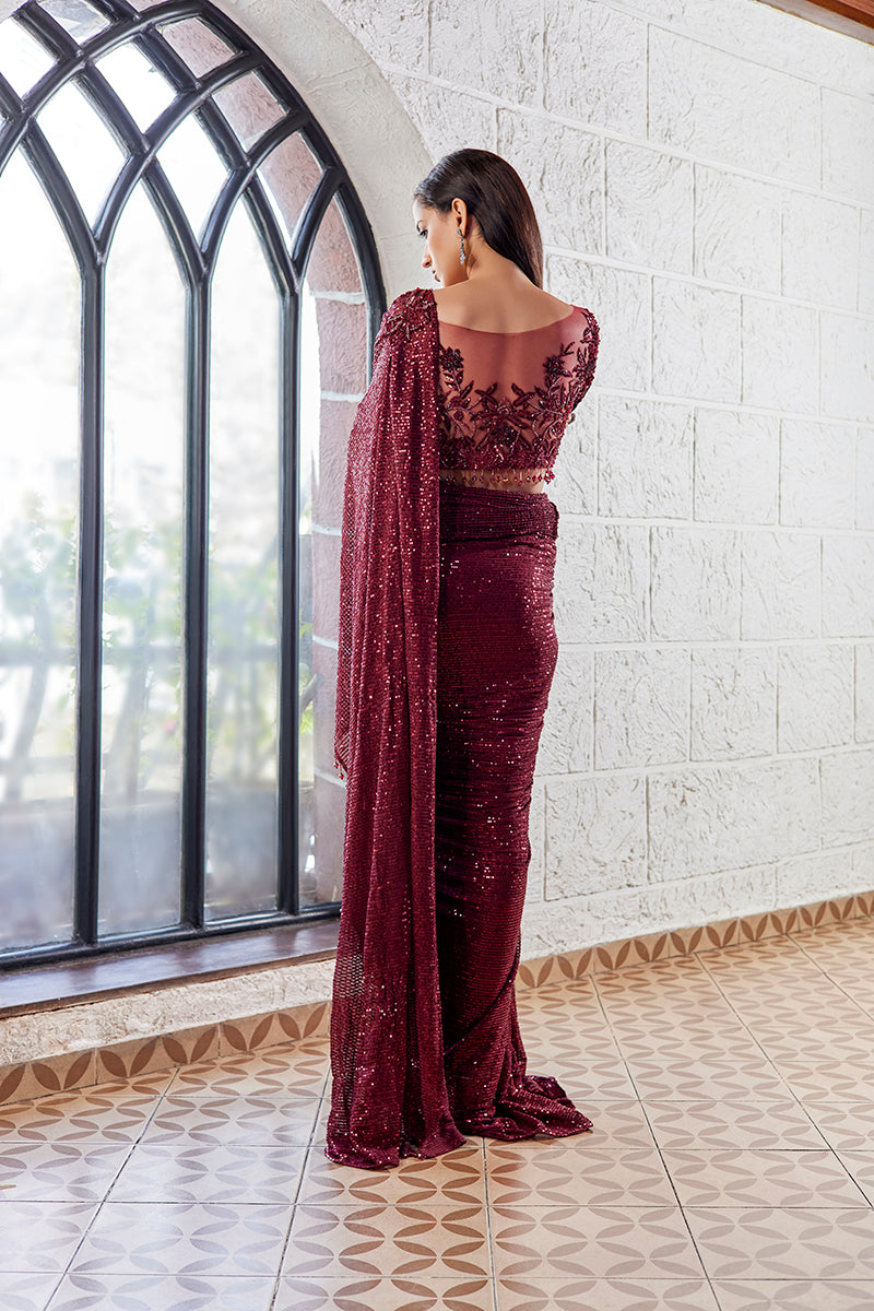A woman poses in an off-white chanderi silk ladies suit from BenzerWorld ethnicwear store, as she leans against a column.
