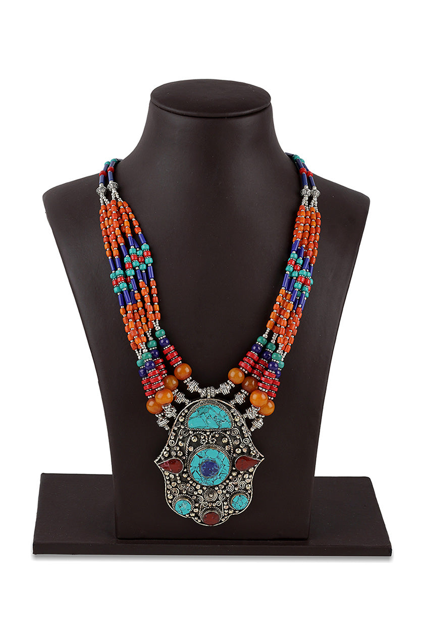 A closeup of a multicoloured necklace with a large pendant from BenzerWorld ethnicwear store.