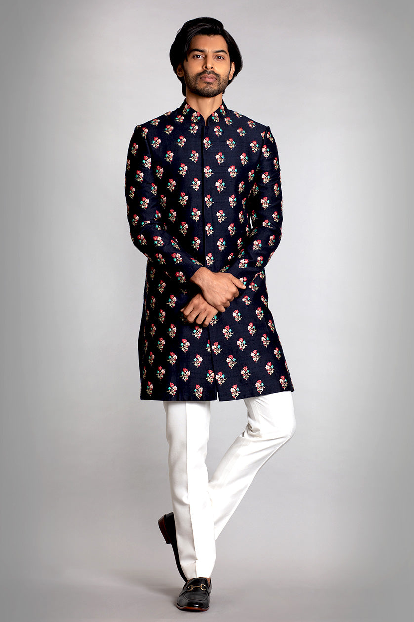 A man poses in a navy blue silk sangeet outfit from BenzerWorld ethnicwear store.