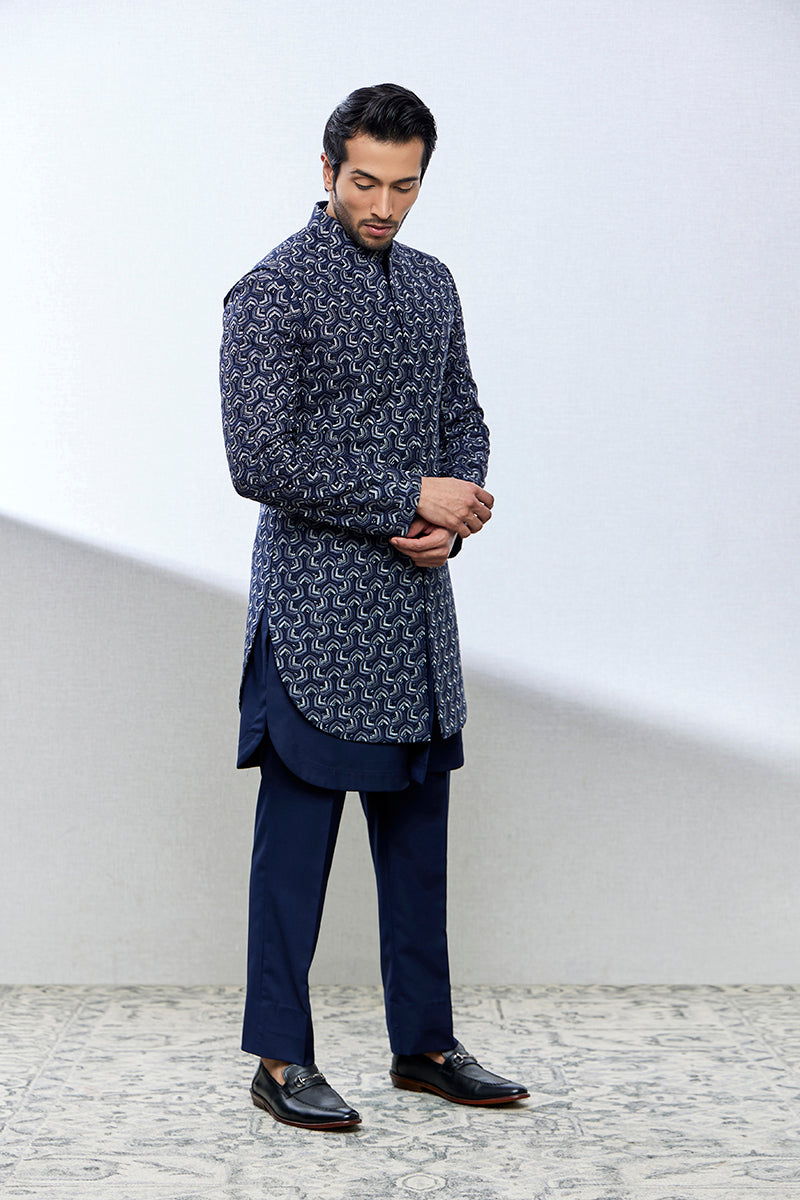 A man poses in a navy blue tencel silk Indo-Western suit from BenzerWorld ethnicwear store.