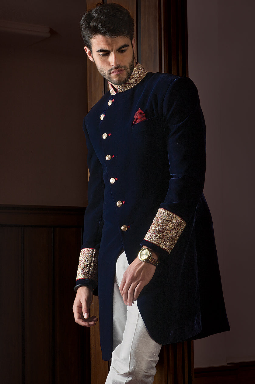 A man poses in a navy blue velvet cocktail outfit from BenzerWorld ethnicwear store.