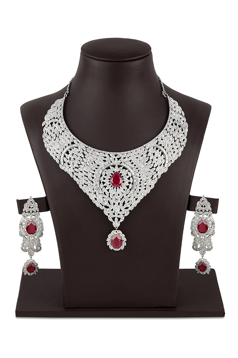 A closeup of a necklace set in cubic zirconia with dangling red stones from BenzerWorld ethnicwear store.