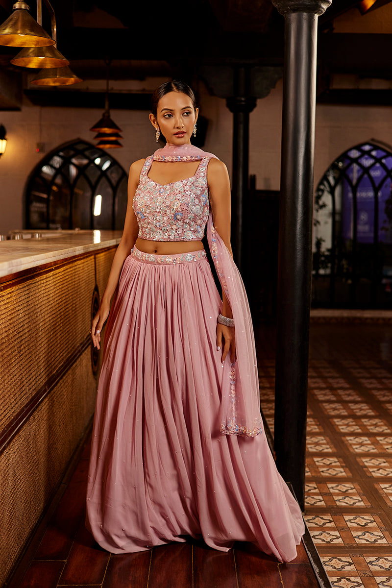 A woman poses in an off-white chanderi silk ladies suit from BenzerWorld ethnicwear store, as she leans against a column.