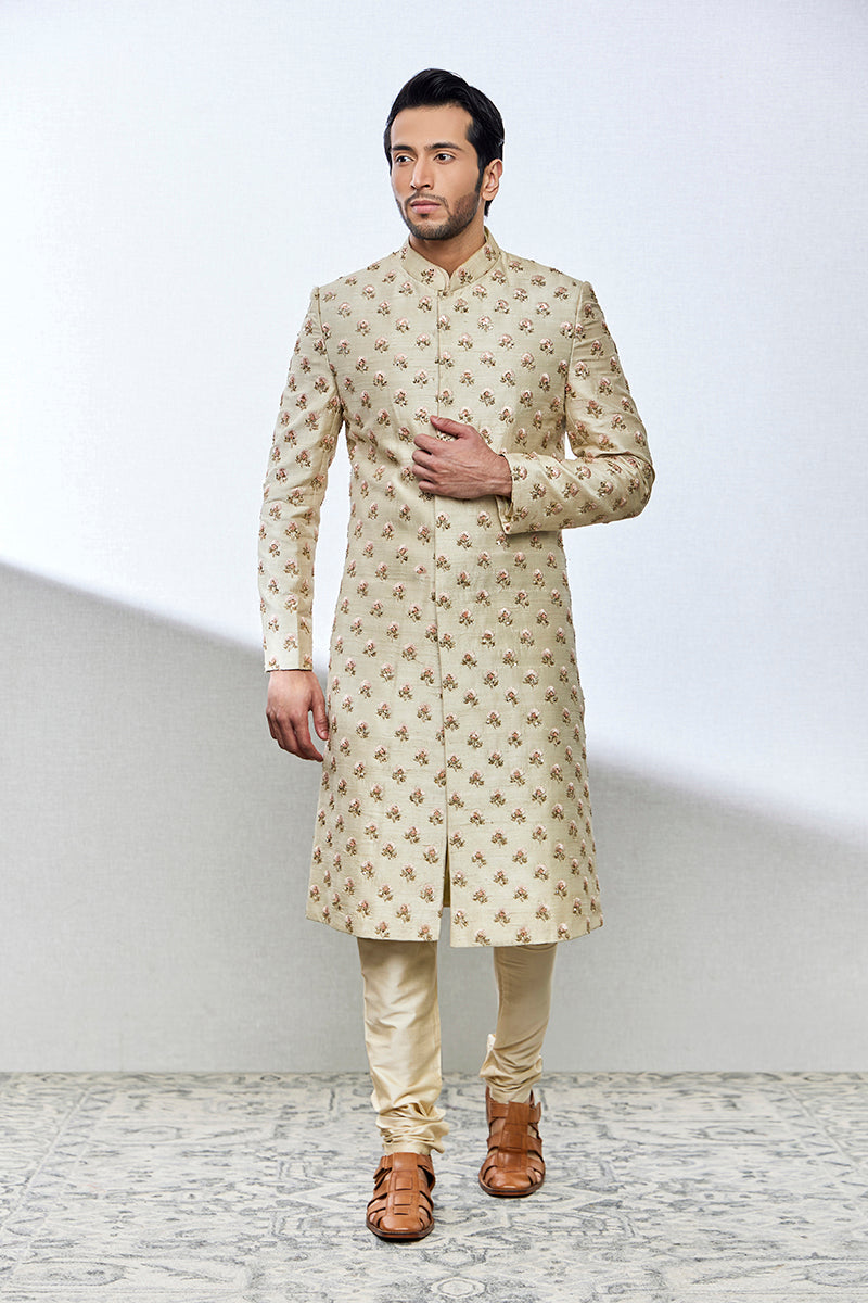 A man poses in a pista green raw silk sherwani from BenzerWorld ethnicwear store.