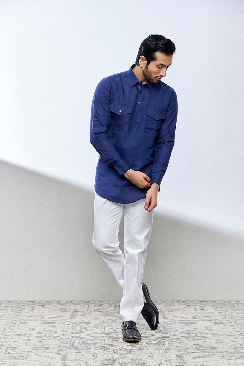 A man poses in a royal blue linen shirt from BenzerWorld ethnicwear store while rolling his sleeves.
