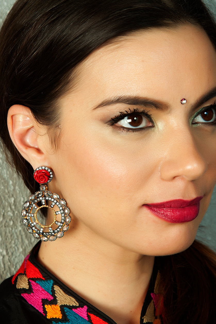 A closeup of a woman wearing uncut American diamond earrings in black rhodium plating from BenzerWorld ethnicwear store.