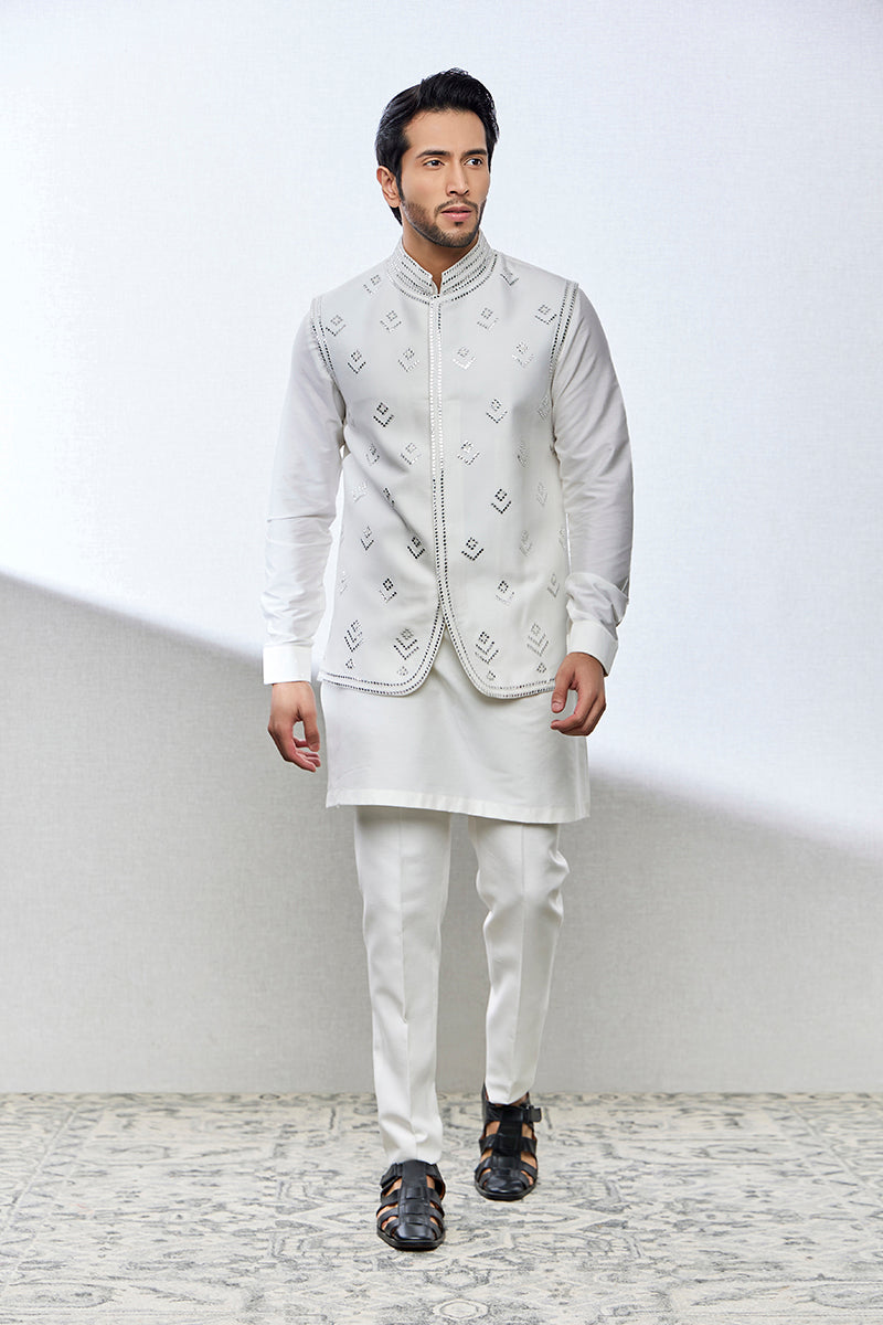 A man poses in a white cotton silk kurta set from BenzerWorld ethnicwear store.