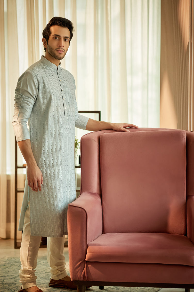 A man in a light blue cotton silk kurta set from BenzerWorld ethnicwear store poses.