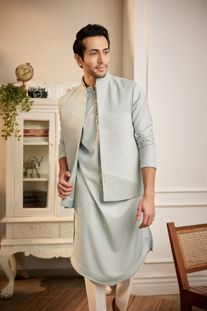 A man in a powder blue terrywool kurta and bundi set from BenzerWorld ethnicwear store poses for the camera.