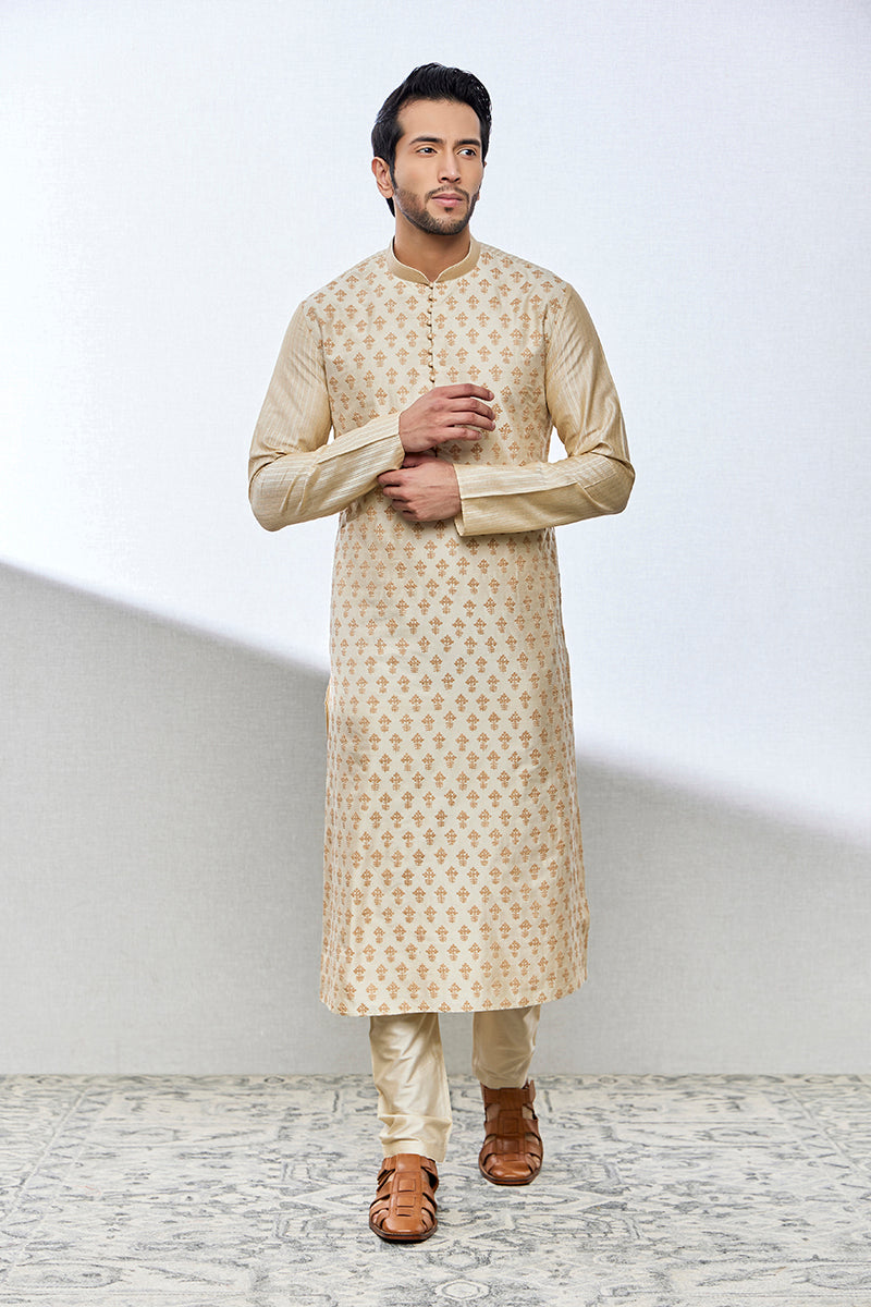 A man poses in a beige cotton silk kurta set from BenzerWorld ethnicwear store.