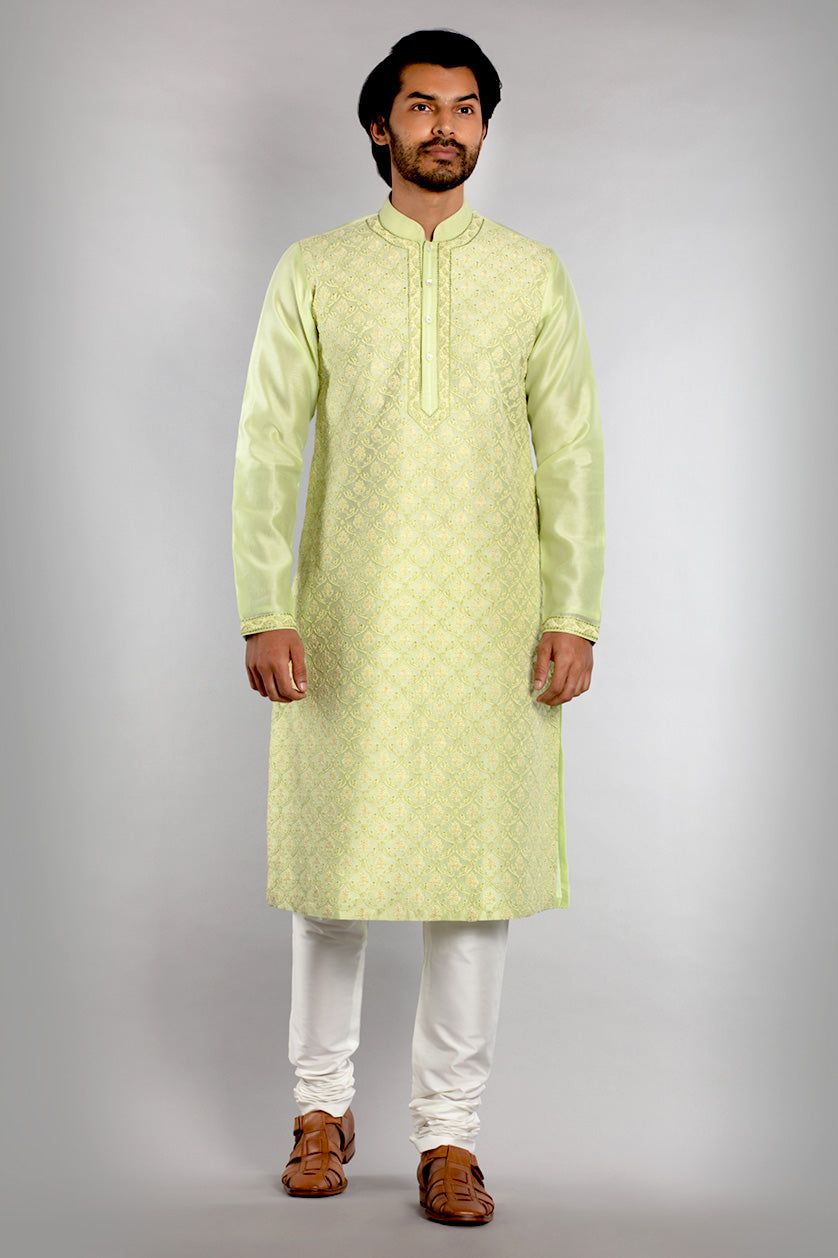 A man poses in a pista green cotton silk embroidered kurta set from BenzerWorld ethnicwear store.