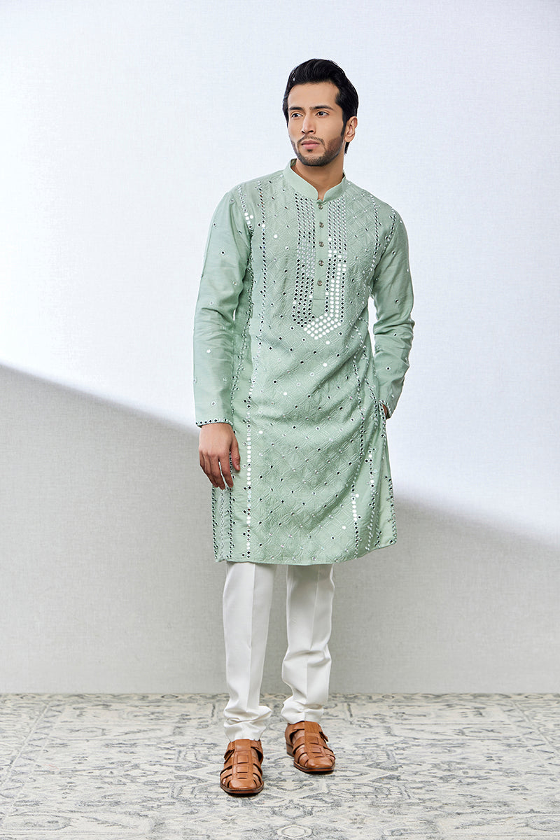 A man poses in a mint green munga silk kurta set from BenzerWorld ethnicwear store.