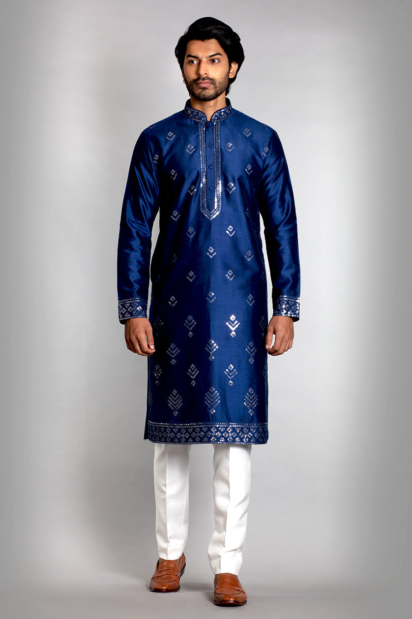 A man poses in a royal blue cotton silk embroidered kurta set from BenzerWorld ethnicwear store.