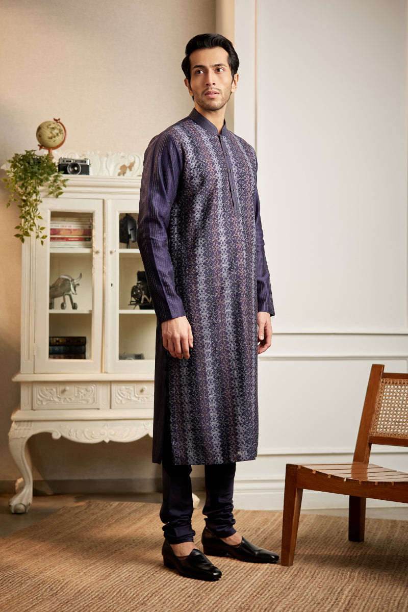 A man in a navy blue chanderi silk kurta set from BenzerWorld ethnicwear store poses for the camera.